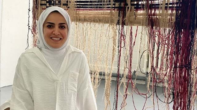 Student front of her art design