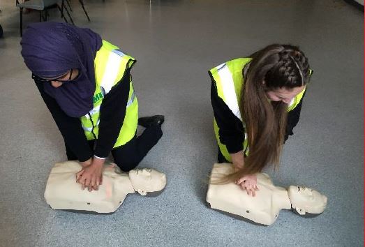 Students practising CPR on dummies during a HealthReach workshop