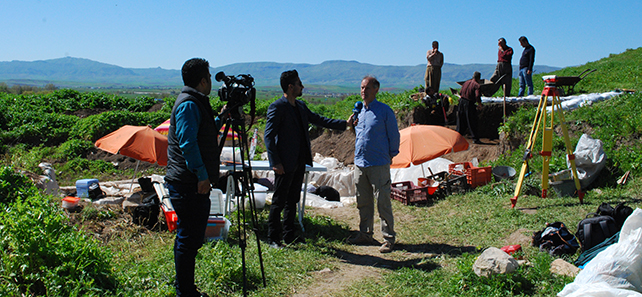 An academic being interviewed at a dig