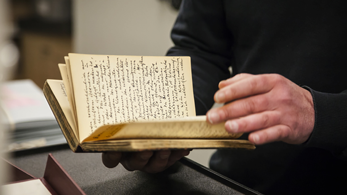 Closeup of lecturer holding a diary owned by Samuel Beckett