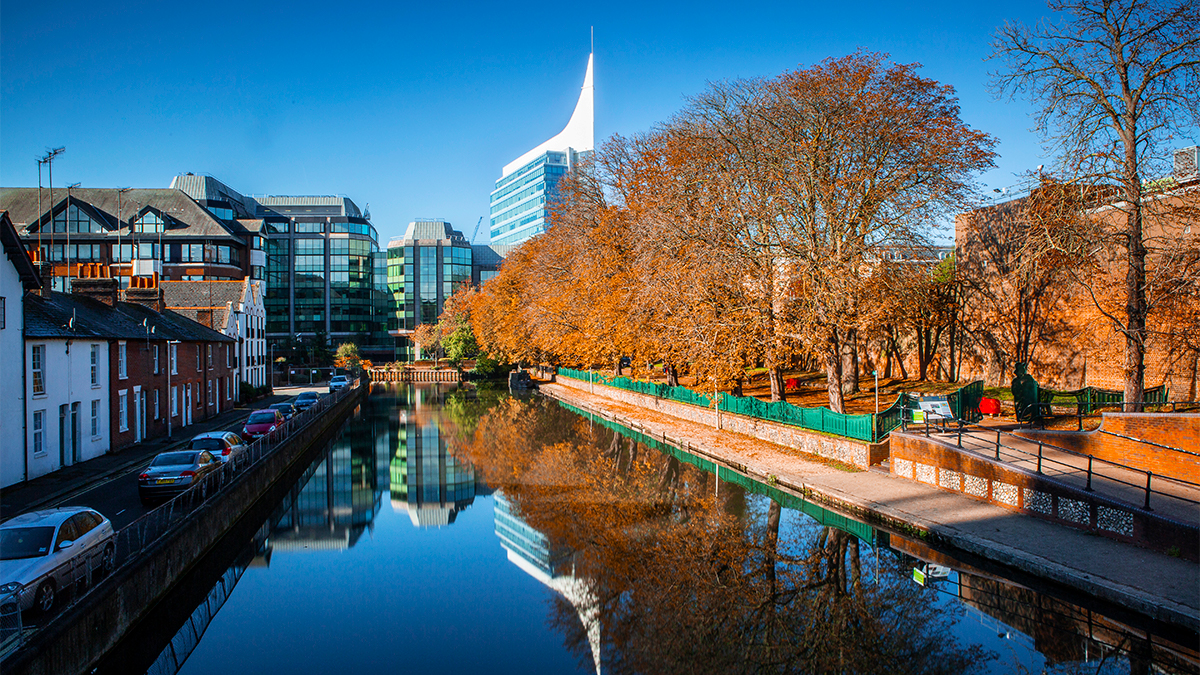 View of the Kennet canal in Reading town centre with autumnal trees and rows of houses on either side