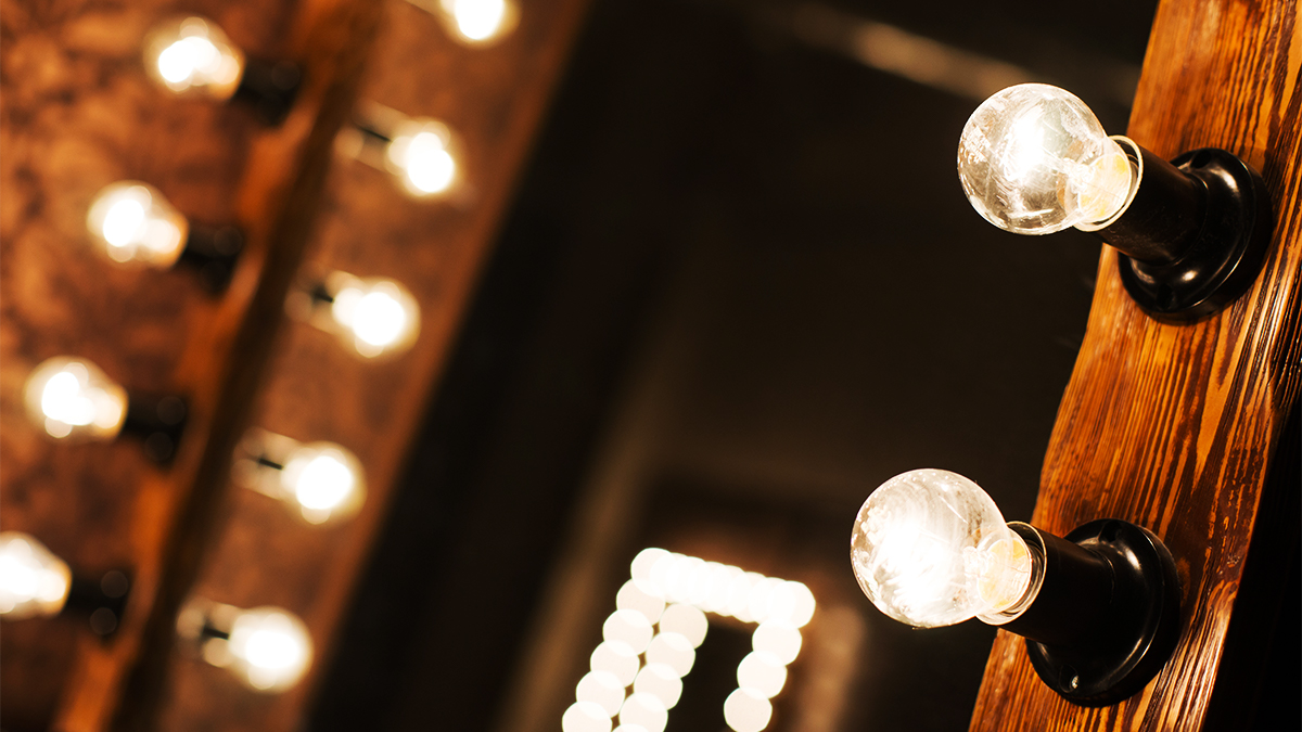 Close up of lightbulbs on a mirror in a theatre dressing room.