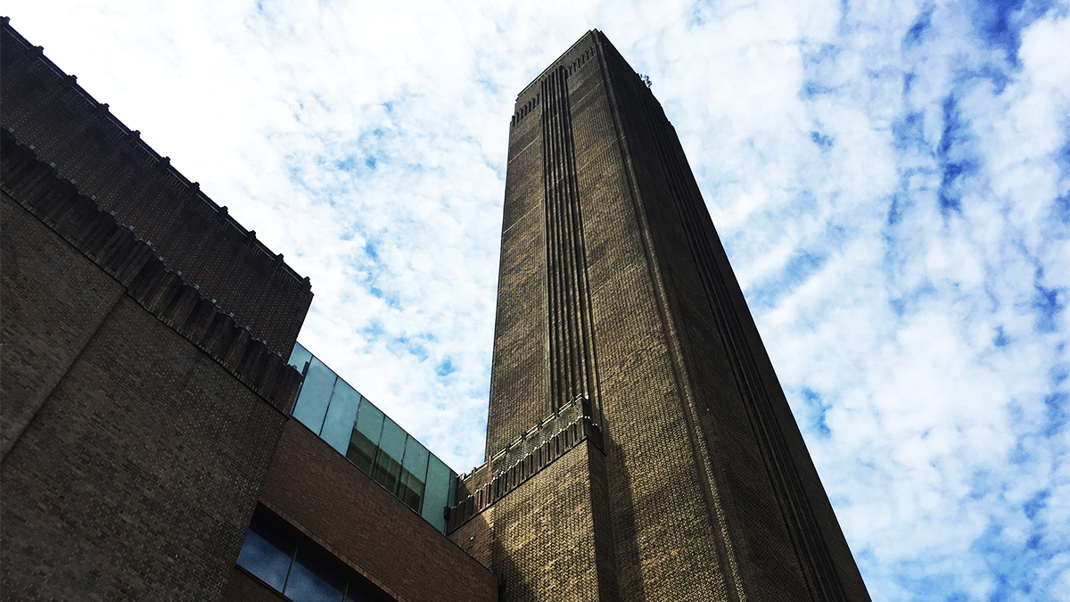 Upward facing angle of the Tate Modern smokestack against a cloudy sky