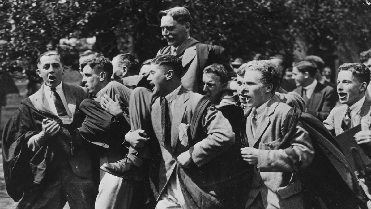 Black and white photo of Dr W. M. Childs being carried through University of Reading grounds in 1926.