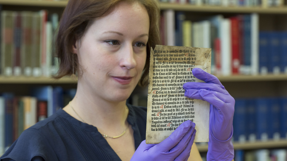 a woman holding one of the Caxton pages
