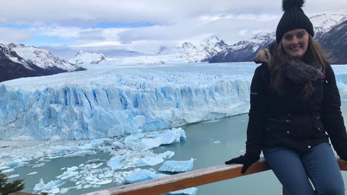 Megan Johnson, French and Spanish graduate, standing in front of a glacier in Argentina