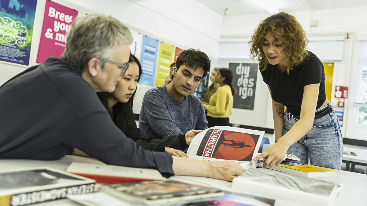 Professor Sue Walker showing examples of poster design to BA Graphic Communication students