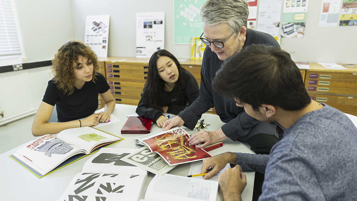 Professor Sue Walker discusses printed materials with BA Graphic Communications students