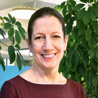 Headshot of women with brown hair smiling at camera