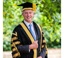 Male Chancellor in his robes smiling at the camera