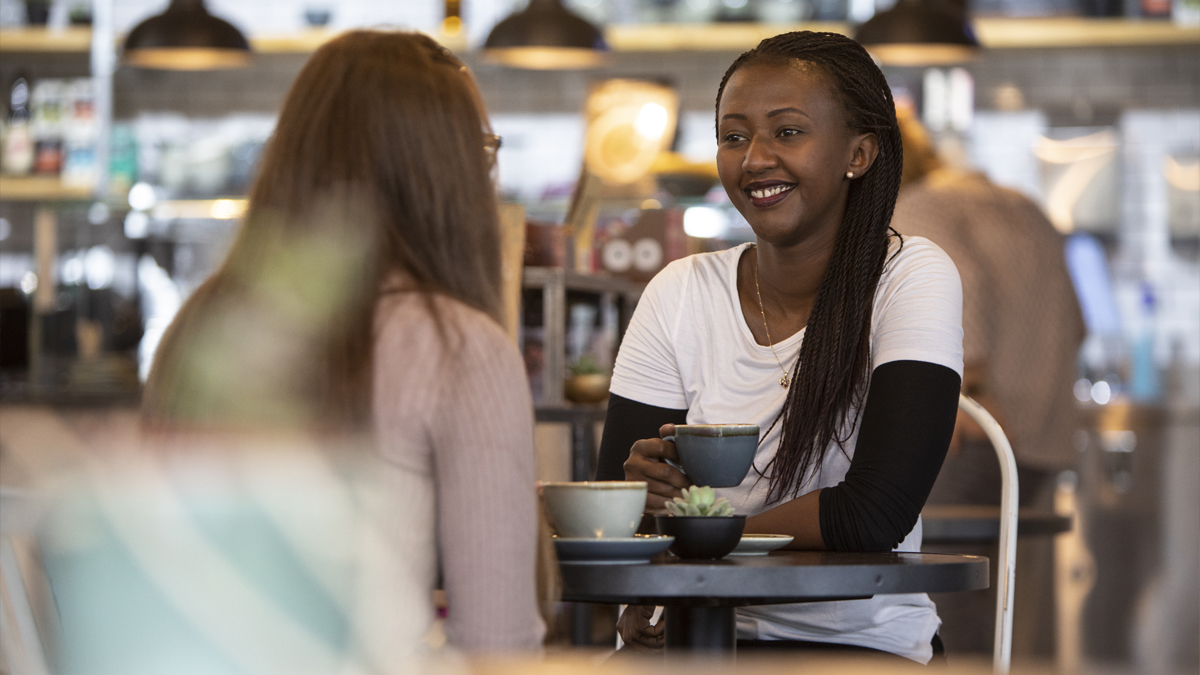 Pair of students chatting over a coffee