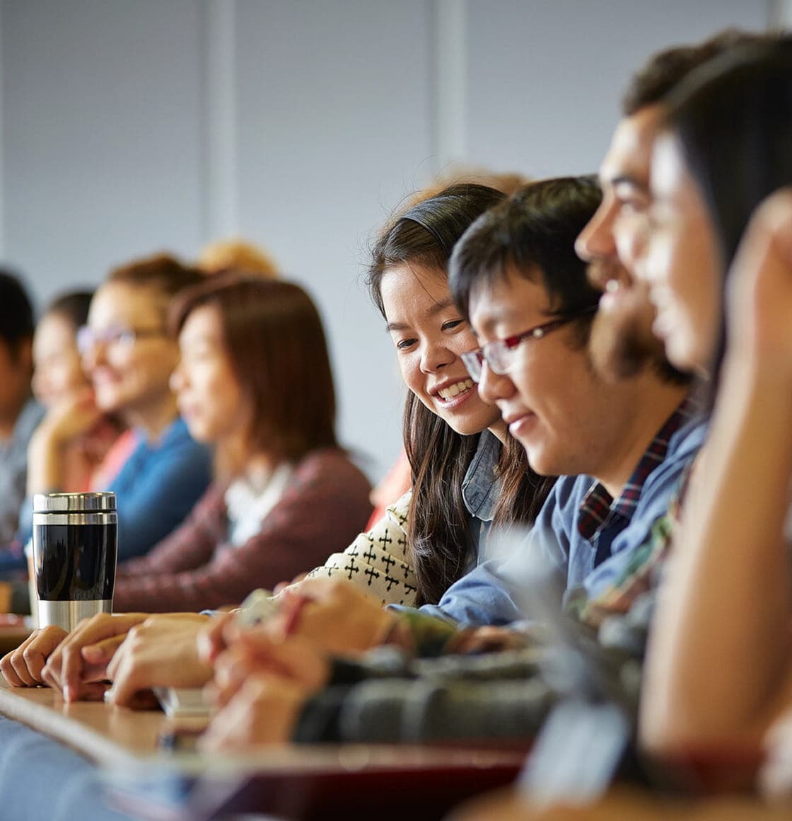 Students listening and taking notes during a university lecture.