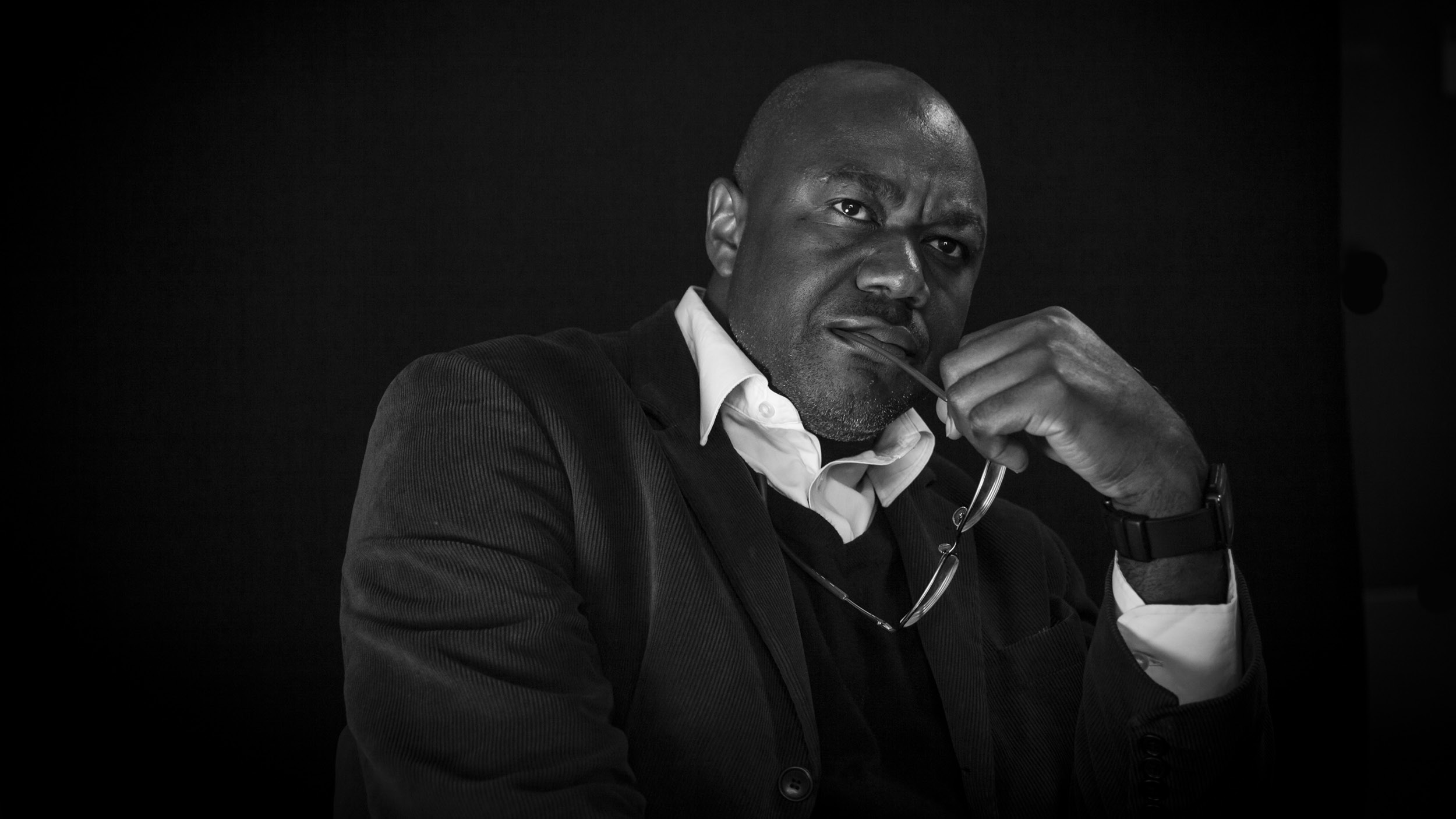 Black and white portrait of a smartly dressed man looking reflective