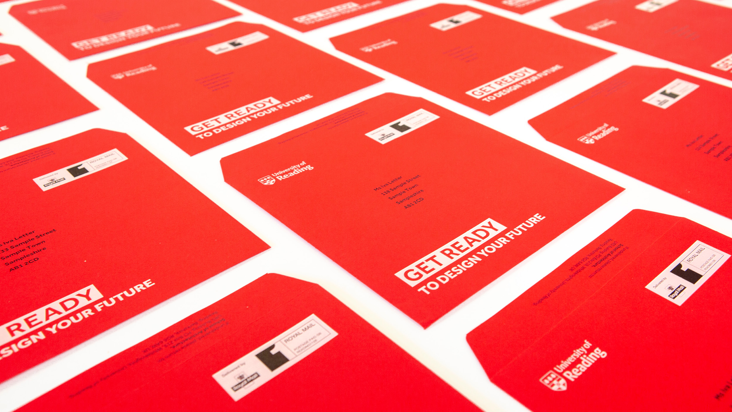 Bright red envelopes with white print, laid out on a table