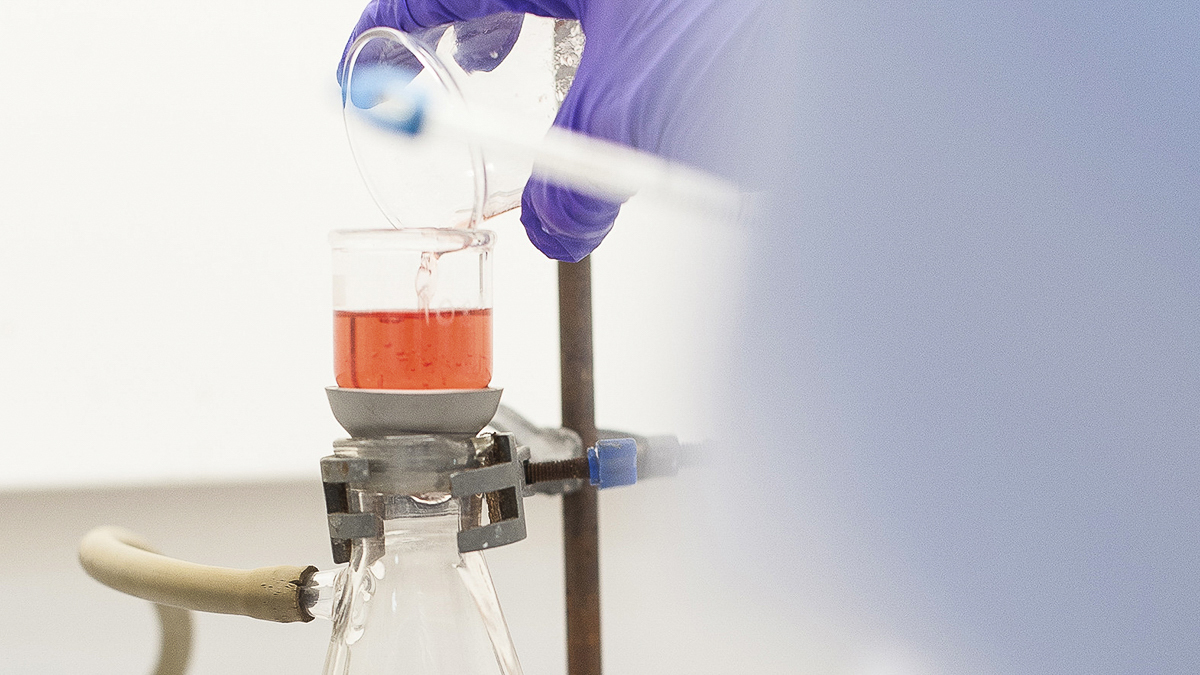 Scientist pouring liquid into a beaker