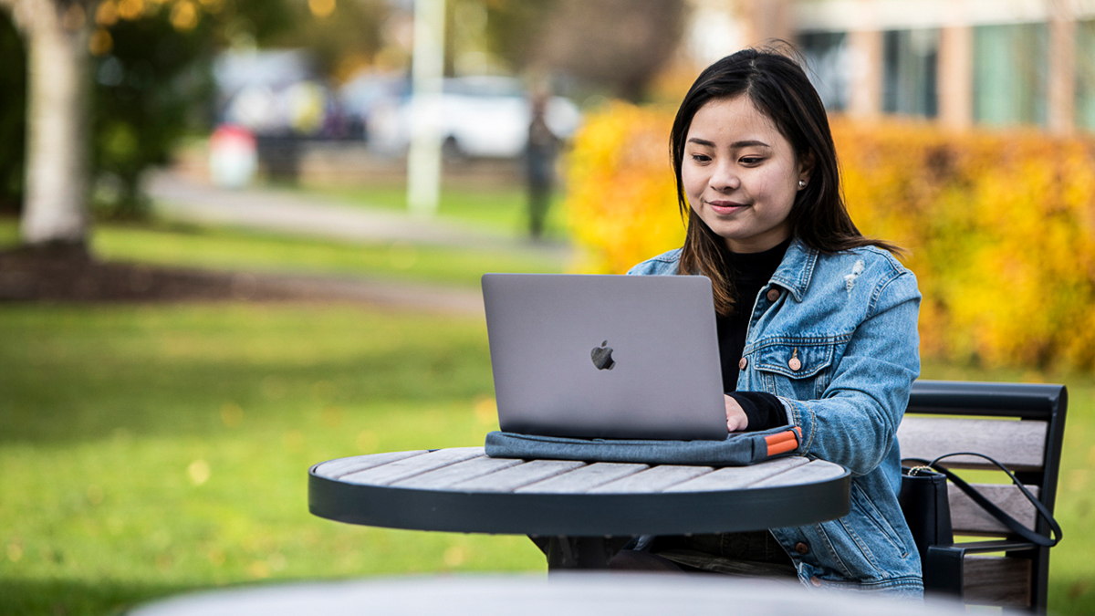 A student using her laptop outside a cafe
