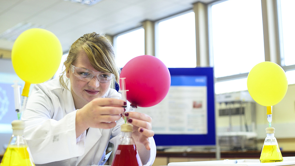 Student experimenting with gas-filled balloons