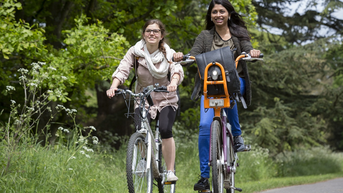 Two students cycling on a bike path