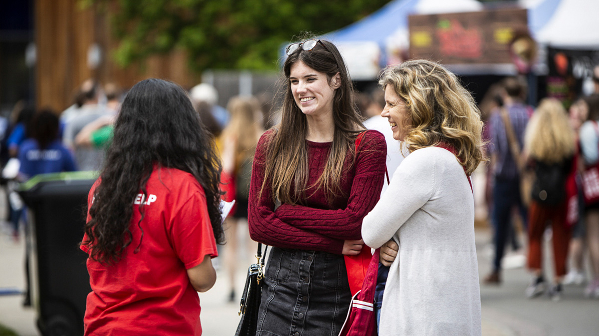 A student volunteer talking to visitors at Open Day