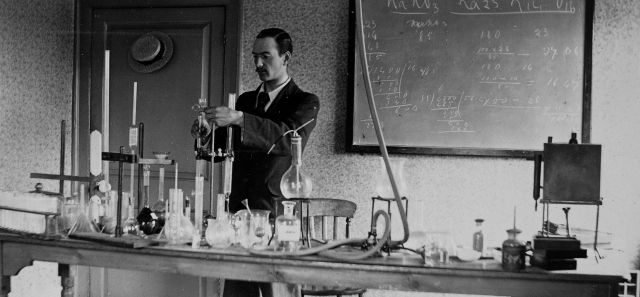 Black and white photograph of an academic in a laboratory carrying out an experiment