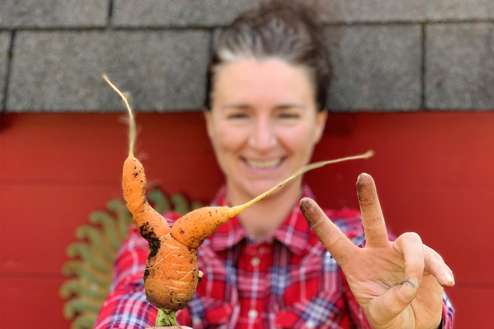 Woman holding a highly abnormal carrot