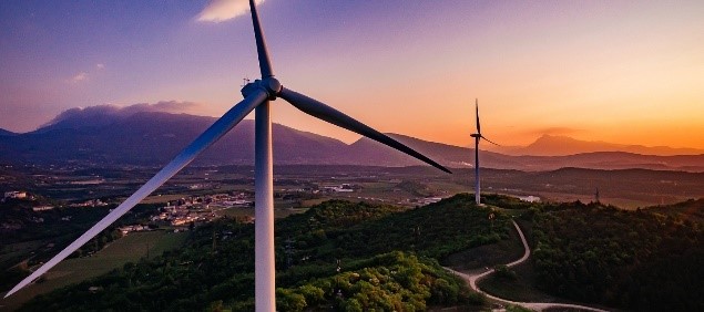 Wind turbines at sunset in a hilly landscape