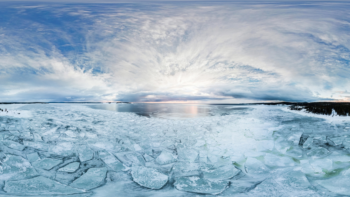 Wide view of an icy landscape with the ocean in the distance.