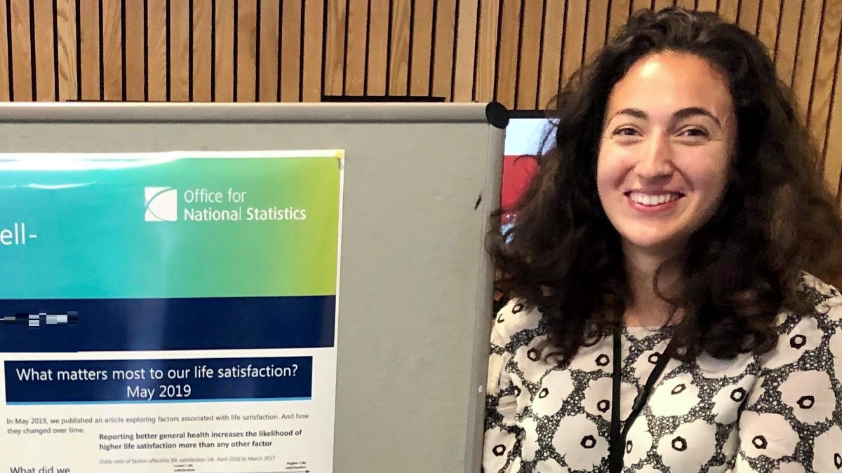 Meera Parmar standing next to aa poster for Office for National Statistics 