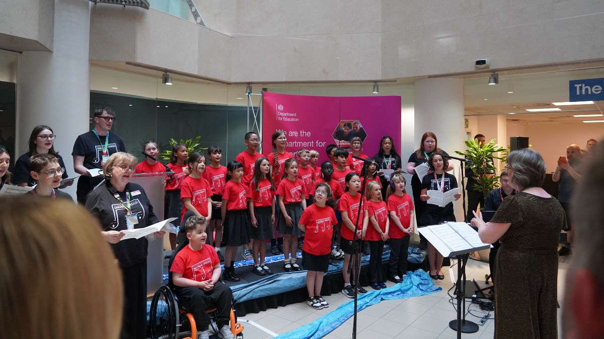 Choir perorming on small reception stage, conductor in view to the right.