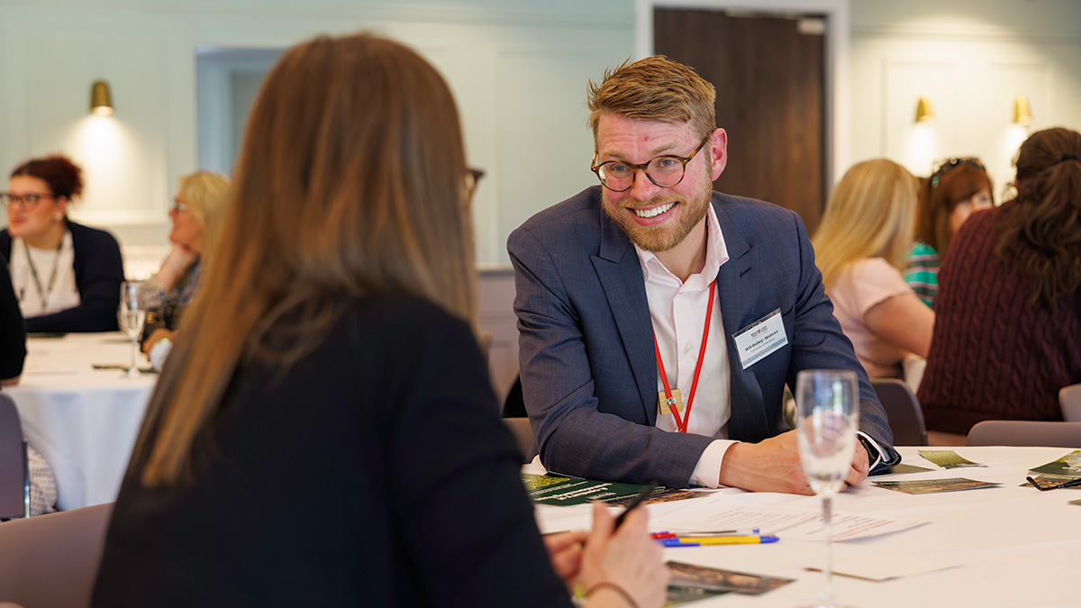 Two teaching professionals talk at a meeting