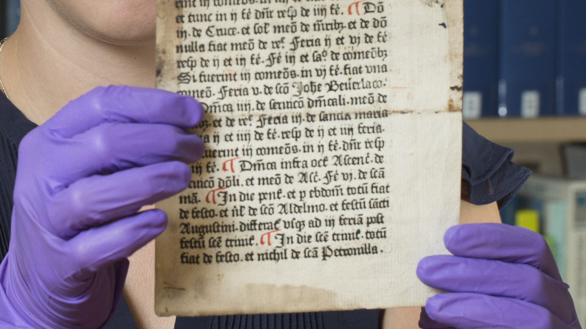 medieval Caxton pages being handled