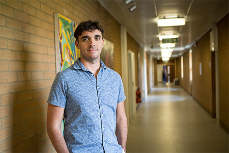 Ugo Marsili standing in a University corridor