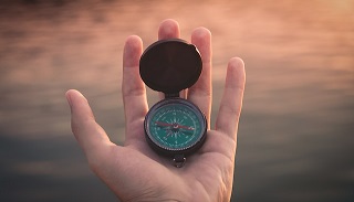 A hand holding a compass