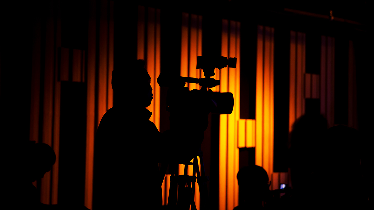Student cameraman working in shadow in a theatre