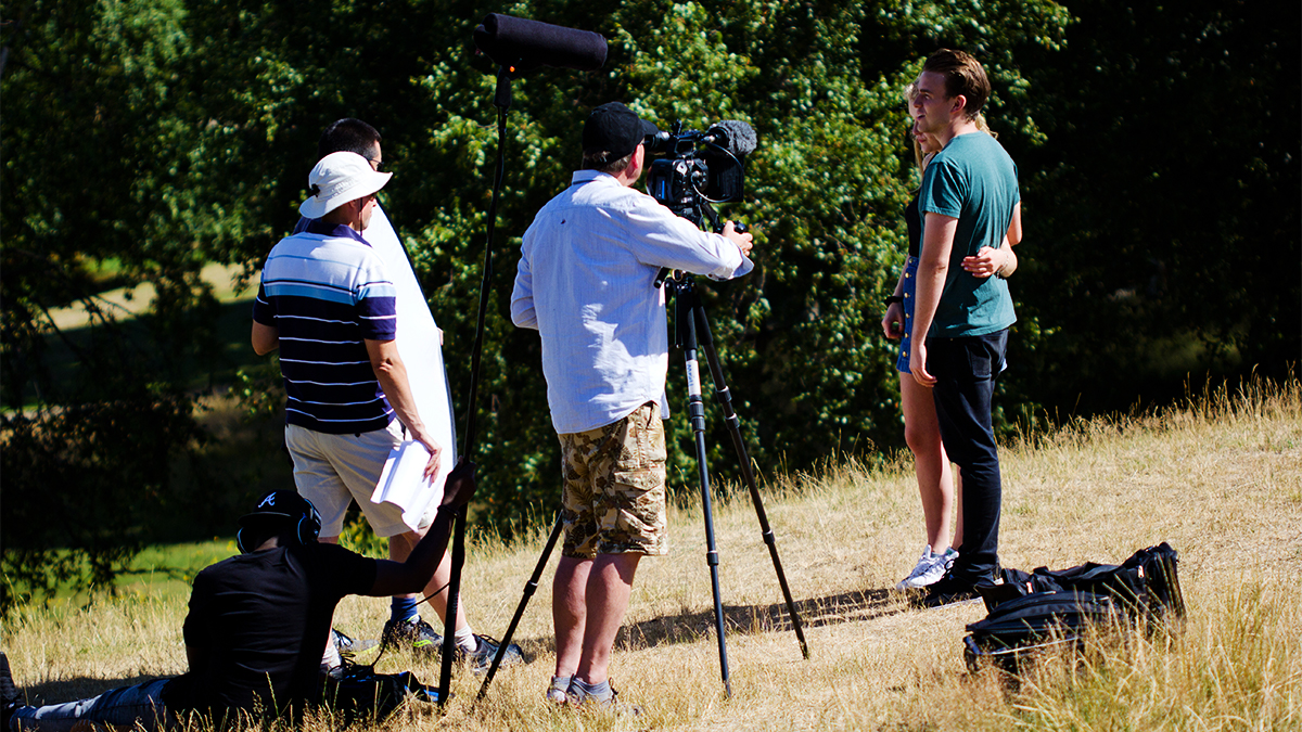 Film students shooting a scene on location in front of a tree