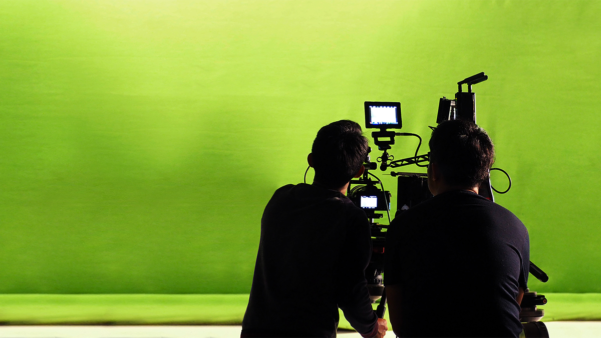 Two film students shooting a green screen