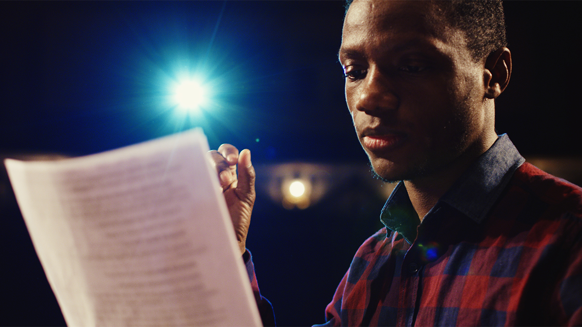 Undergraduate student reading a script against backlighting