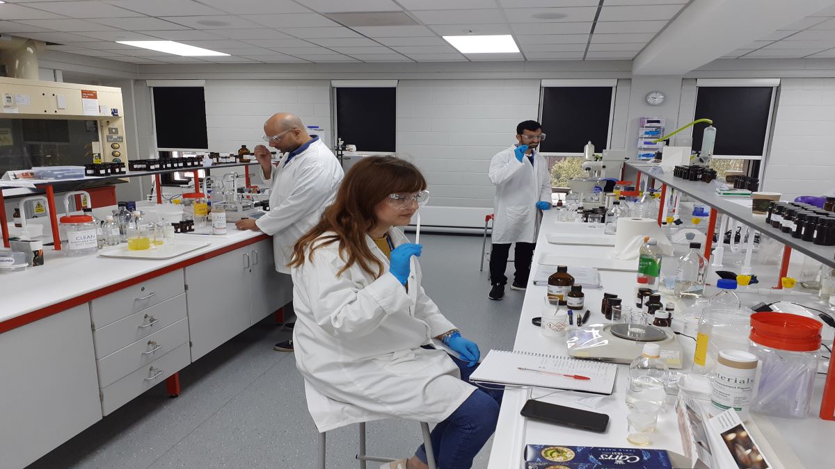 Three people in a laboratory testing flavour samples