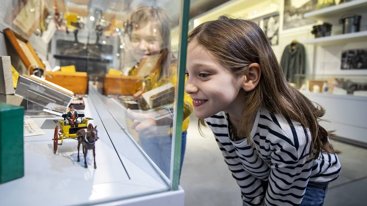 Young girl looking into display cabinet at the Museum of English Rural Life