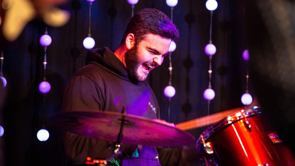 A man enthusiastically drumming