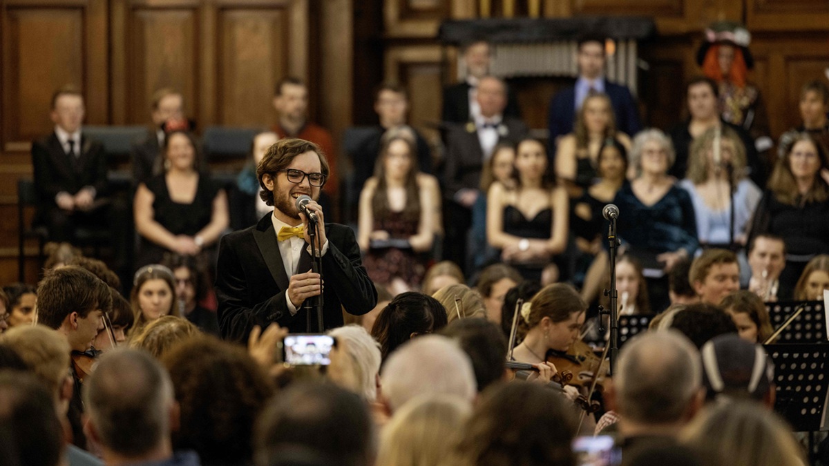 A man doing a musical performance to a crowd in a concert hall