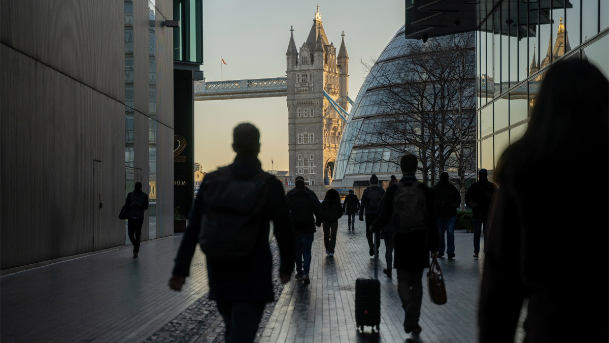 Commuters walking towards Tower Bridge at dawn
