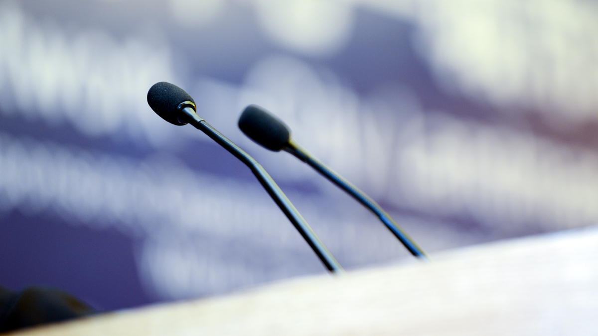 Close up of two microphones on a wooden lectern