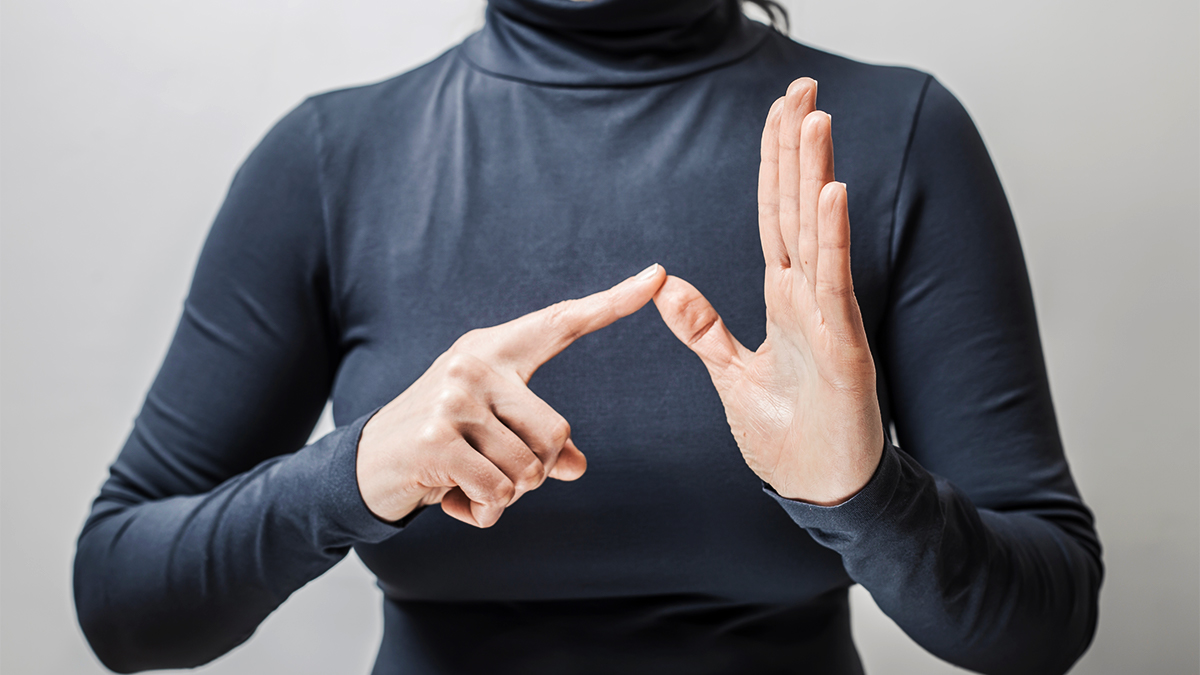 Close up of woman's hands spelling out a word in sign language