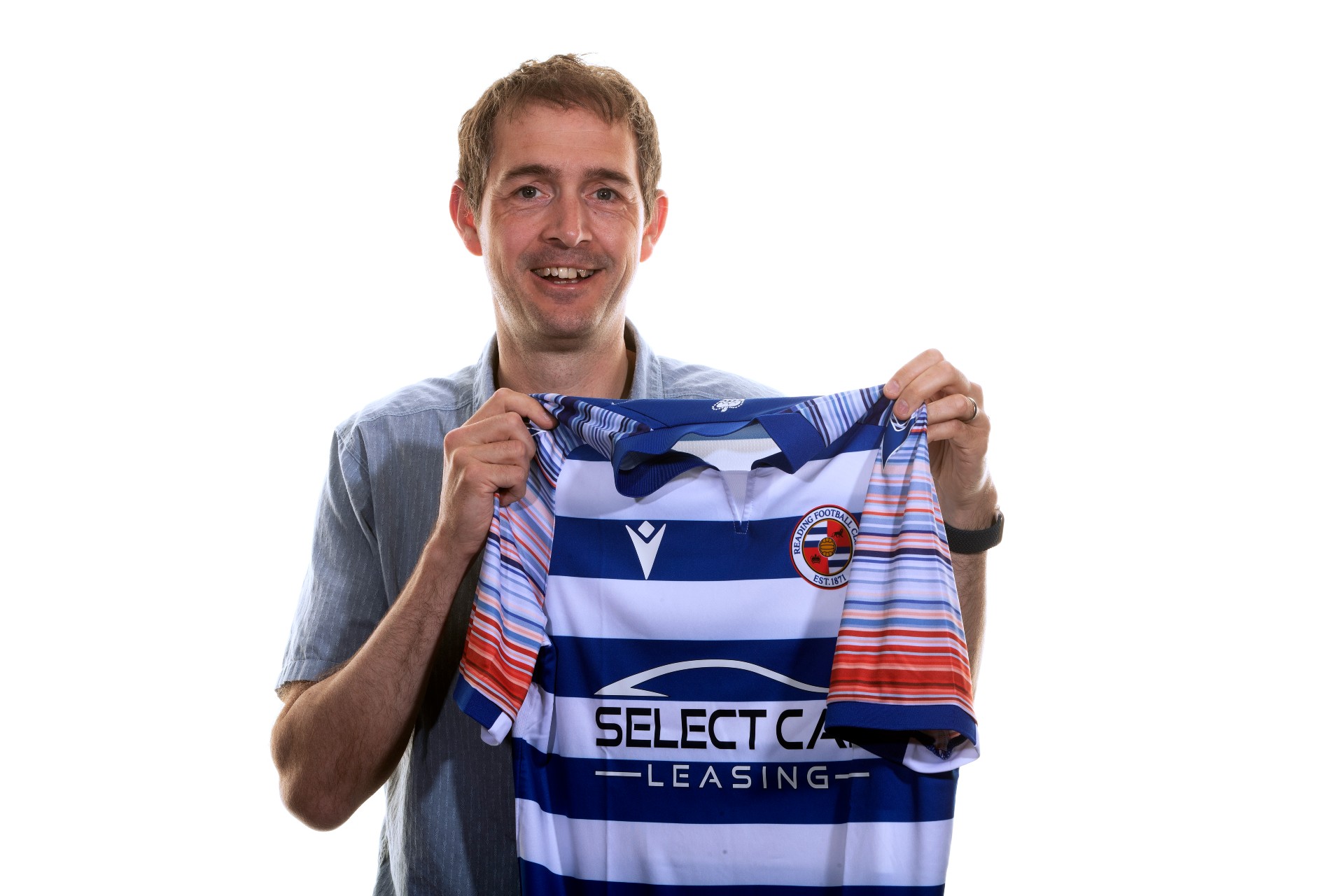 Professor Ed Hawkins holding the new Reading FC 2022/23 season home shirt, which features the climate stripes he designed