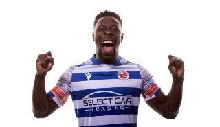 Reading FC men's footballer Andy Yiadom models the new 2022/23 home season shirt, which features the climate stripes on its sleeves