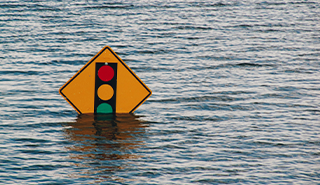 a traffic light road sign partly submerged underwater in a flood