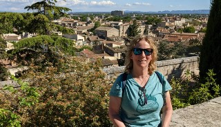 Estates colleague Heather Silk-Jones sat on a wall in Girona, Spain, with the city in the background
