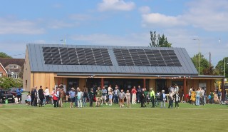 A crowd of people gathered outside the new Manor Ground pavilion
