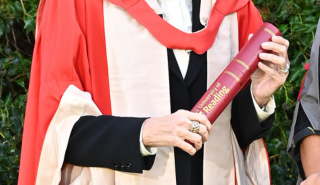 A woman holding an honorary degree from the University of Reading